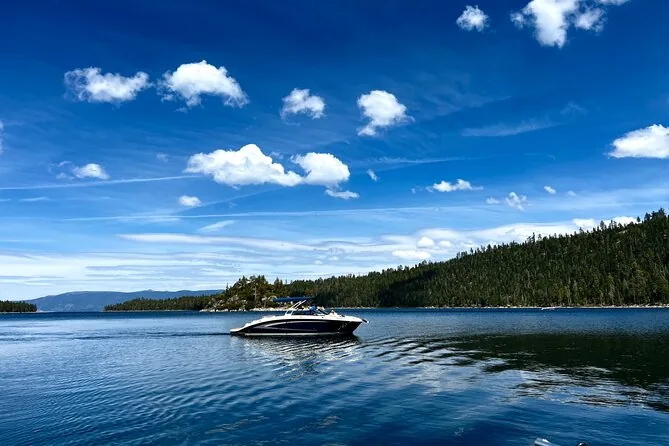 A private motorboat on deep blue water with forested shores